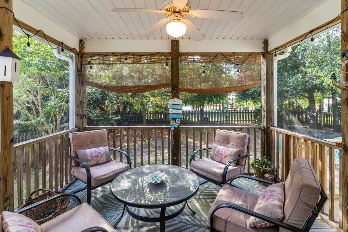 The image showcases a tranquil, sun-dappled living space with a cozy seating area arranged around a stylish glass table. Thoughtful decorative accents and soft, natural light create a welcoming, relaxing atmosphere perfect for unwinding or connecting with loved ones.